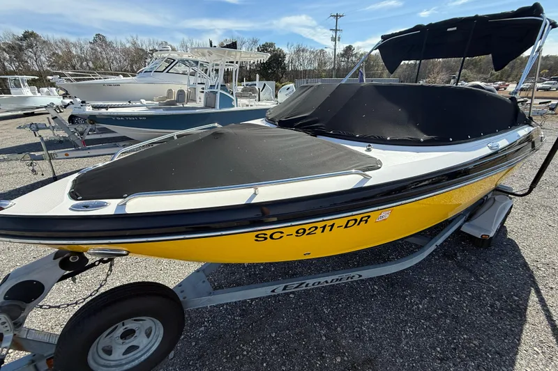 Slide: The Image of 2014 Monterey 197 Blackfin boat with yellow hull on trailer, covered and parked outdoors. - 3