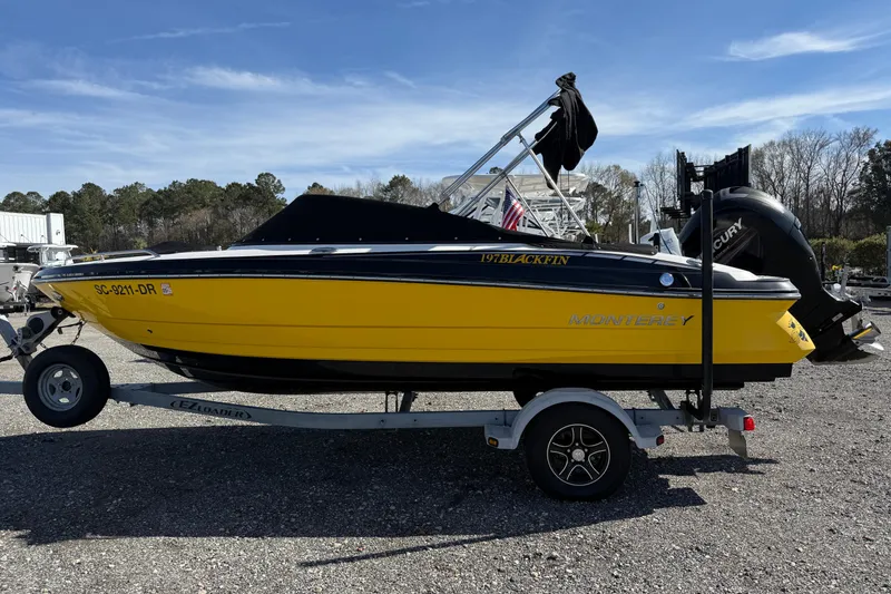 Slide: The Image of 2014 Monterey 197 Blackfin boat in bright yellow on a trailer, parked outdoors. - 4