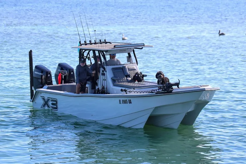 The Image of 2026 Shallow Sport 32 X3 boat on clear blue water with passengers and fishing gear. - 1