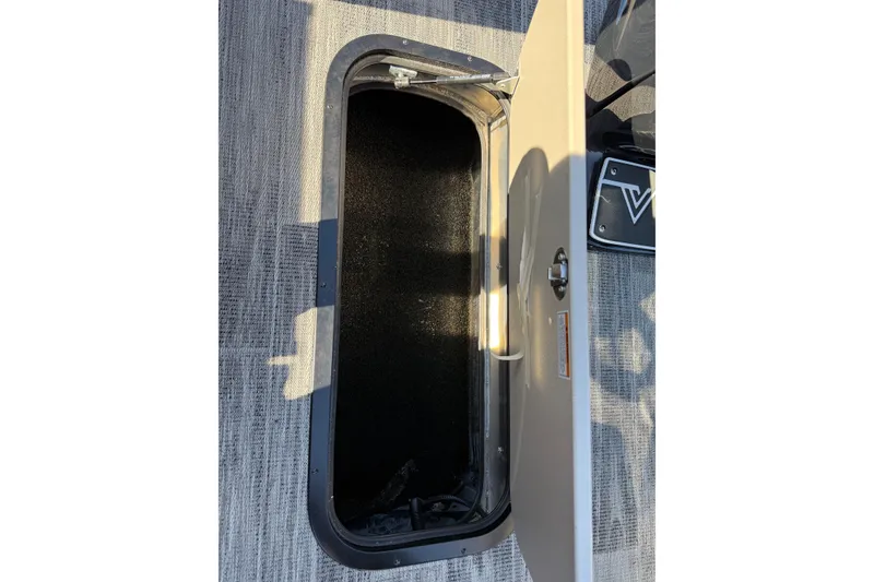 Slide: The Image of Open storage compartment in 2026 Viaggio X22Q boat, featuring carpeted interior and secure latch. - 15