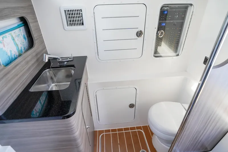 Slide: The Image of 2024 Invincible 43 Open Fisherman boat interior with sink, toilet, and control panel. - 43