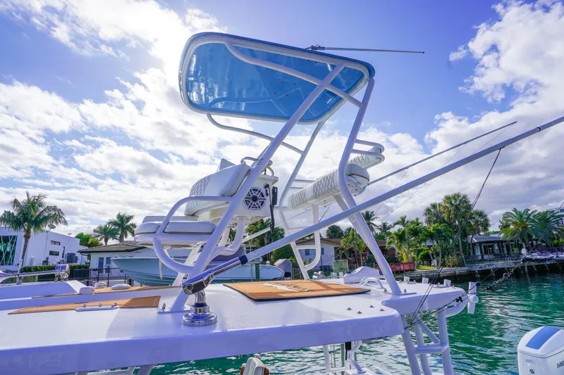 Slide: The Image of 2024 Invincible 43 Open Fisherman boat with elevated seating, docked by palm trees under a blue sky. - 45