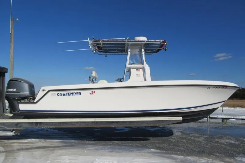 The Image of 2005 Contender 23 CC boat with Yamaha engine on a lift, under clear blue sky. - 0