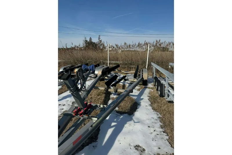 Slide: The Image of Boat trailer for 2005 Contender 23 CC on snowy ground, surrounded by tall grass. - 11