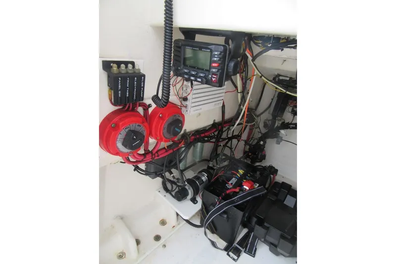 Slide: The Image of Electrical system inside a 2005 Contender 23 CC boat, featuring wiring and control panels. - 13