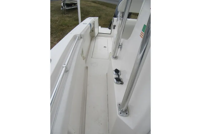 Slide: The Image of 2005 Contender 23 CC boat interior, featuring clean white deck and stainless steel railings. - 16