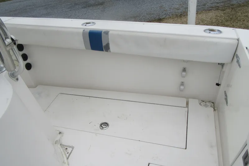 Slide: The Image of 2005 Contender 23 CC boat interior with white seating and storage compartments. - 26