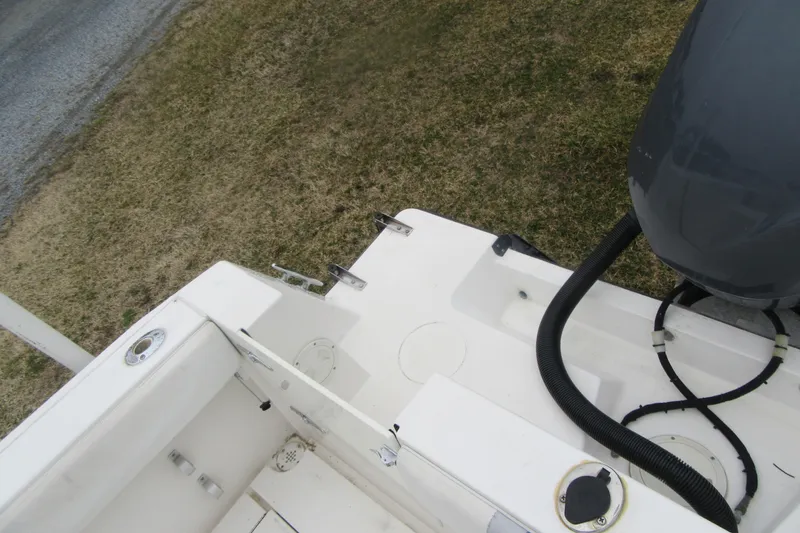 Slide: The Image of 2005 Contender 23 CC boat deck with motor and fittings, on grass. - 31