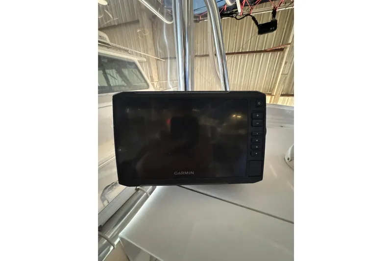 Slide: The Image of Garmin GPS device on 2005 Contender 23 CC boat dashboard in a garage setting. - 6