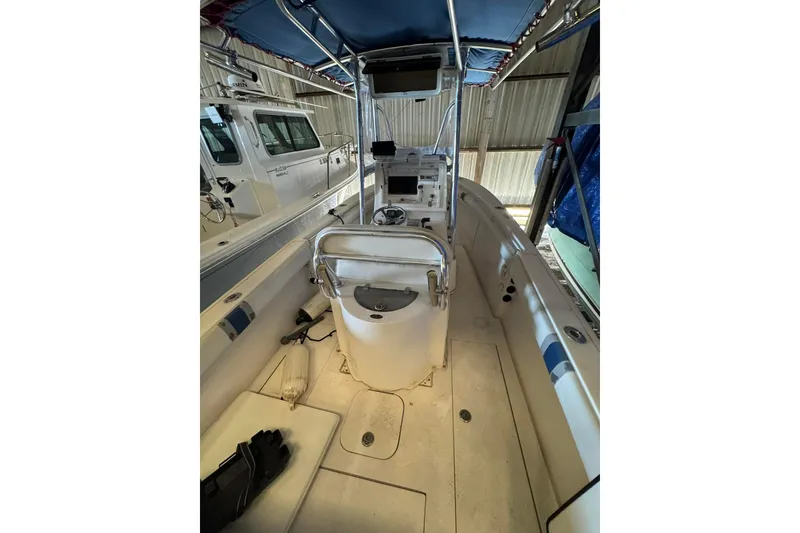 Slide: The Image of 2005 Contender 23 CC boat interior with console and seating, stored indoors. - 8