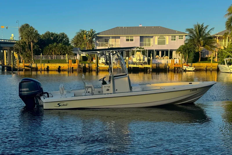 The Image of 2006 Scout 240 Bay Scout boat on calm water near waterfront homes. - 1