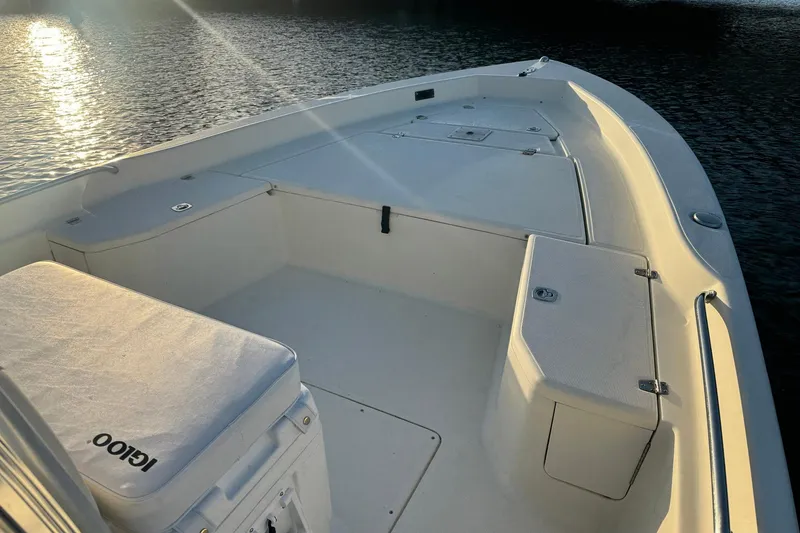 Slide: The Image of 2006 Scout 240 Bay Scout boat interior with seating and storage, on calm water at sunset. - 4