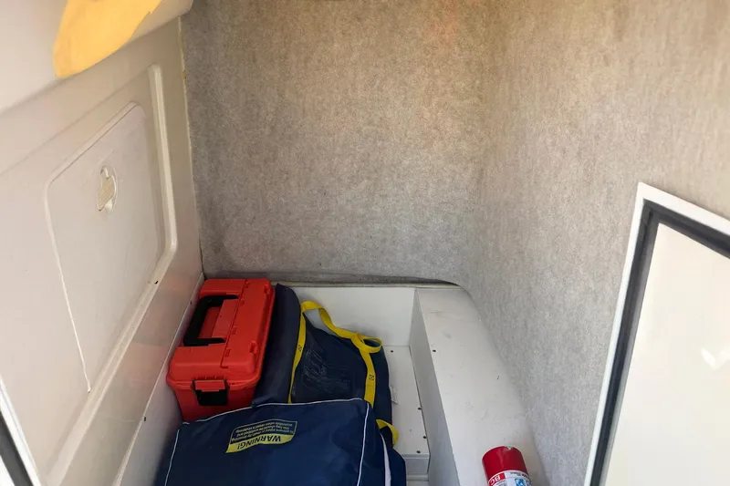 Slide: The Image of Storage compartment of 2006 Scout 240 Bay Scout boat with safety equipment and gear. - 6