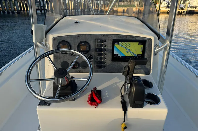 Slide: The Image of 2006 Scout 240 Bay Scout boat dashboard with steering wheel and navigation system. - 7