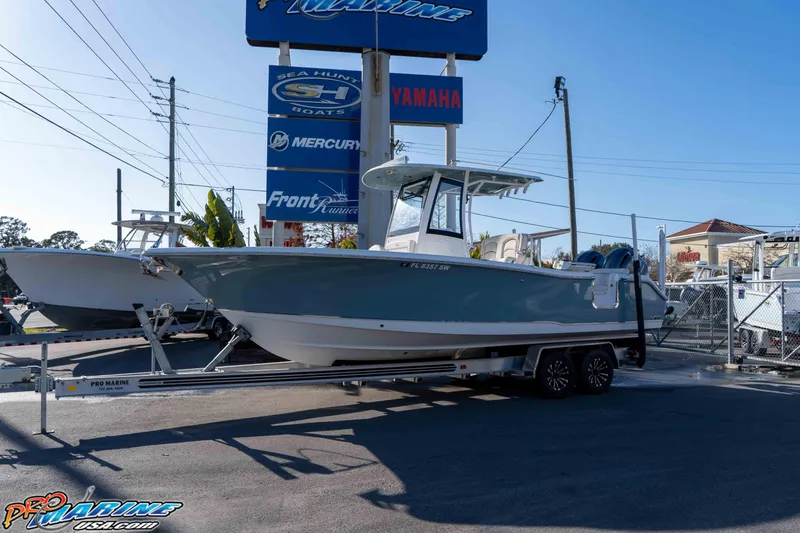 The Image of 2021 Sea Hunt Ultra 265 SE boat on trailer at dealership, sunny day. - 1