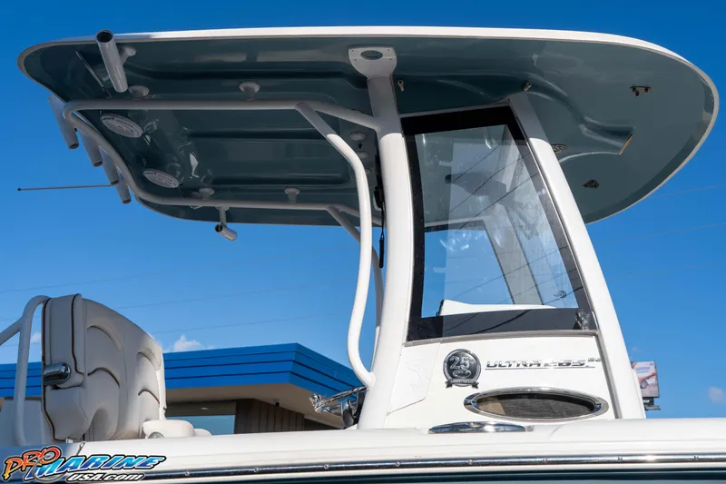 Slide: The Image of 2021 Sea Hunt Ultra 265 SE boat with T-top and console, under clear blue sky. - 17