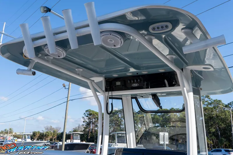 Slide: The Image of 2021 Sea Hunt Ultra 265 SE boat with T-top and rod holders under clear blue sky. - 22