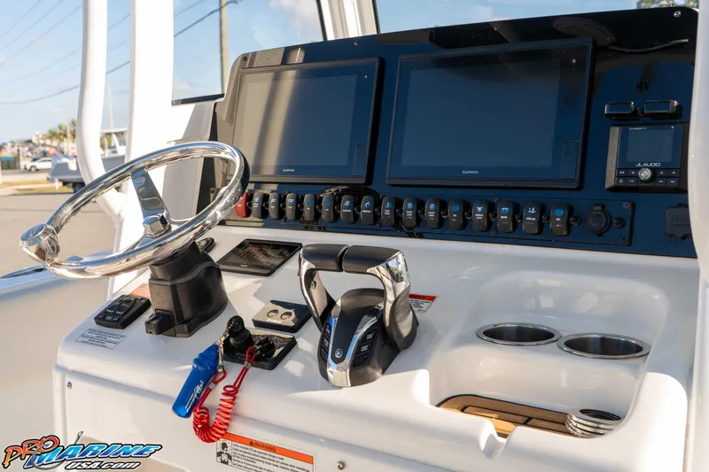 Slide: The Image of 2021 Sea Hunt Ultra 265 SE boat dashboard with steering wheel and electronic controls. - 24