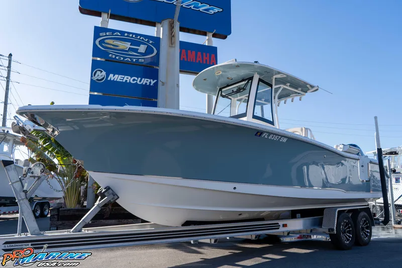 Slide: The Image of 2021 Sea Hunt Ultra 265 SE boat on trailer at dealership, featuring sleek design. - 3
