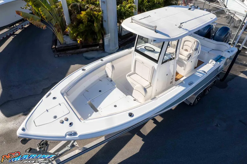 Slide: The Image of 2021 Sea Hunt Ultra 265 SE boat, white exterior, docked with lush greenery background. - 33