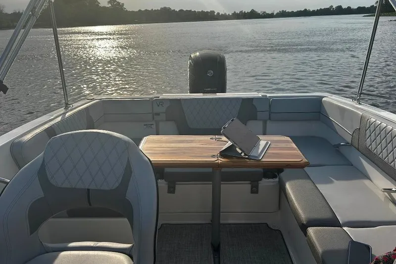 Slide: The Image of 2023 Bayliner VR4 Bowrider OB interior with seating and table on a sunny lake. - 15