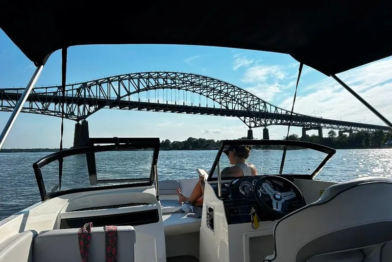 Slide: The Image of 2023 Bayliner VR4 Bowrider OB cruising under a scenic bridge on a sunny day. - 16