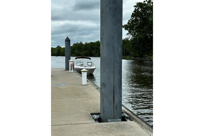 Slide: The Image of 2023 Bayliner VR4 Bowrider OB docked on a calm river under cloudy skies. - 17