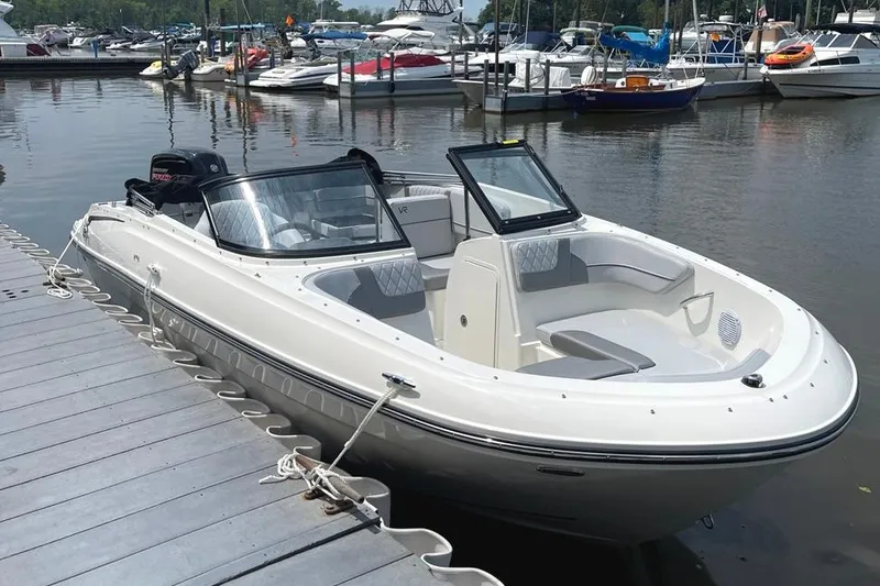 Slide: The Image of 2023 Bayliner VR4 Bowrider OB docked at a marina, showcasing sleek design and spacious seating. - 3