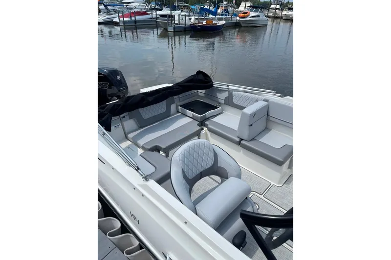 Slide: The Image of 2023 Bayliner VR4 Bowrider OB with sleek seating, docked at a marina. - 6