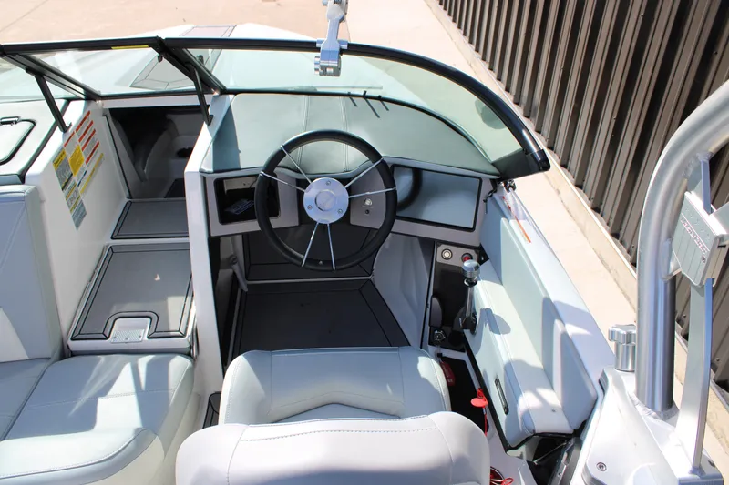 Slide: The Image of 2022 MasterCraft ProStar boat interior with steering wheel and seating. - 4
