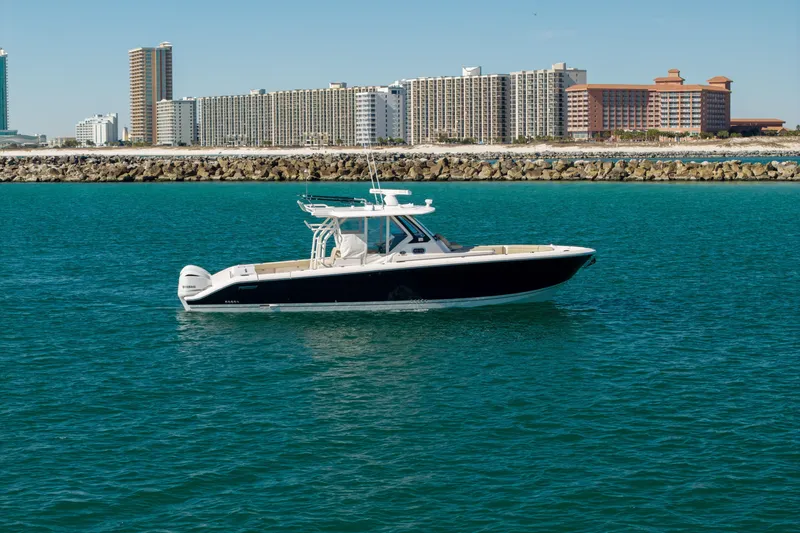 The Image of 2019 Pursuit S 368 Sport boat on blue water with city skyline background. - 1