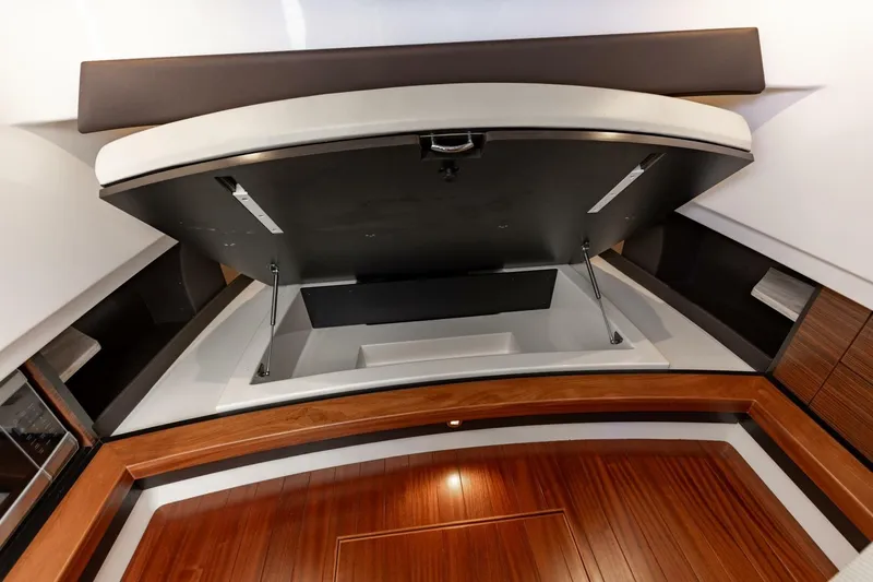 Slide: The Image of 2019 Pursuit S 368 Sport interior storage compartment with wooden accents and modern design. - 10