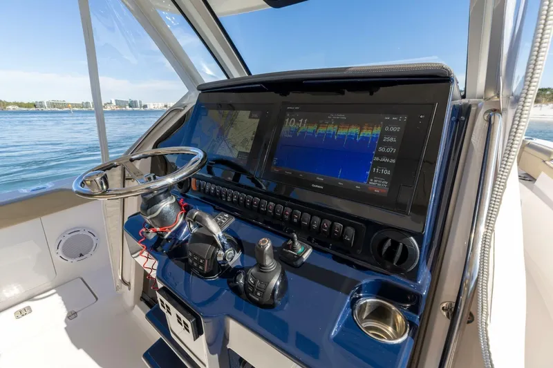 Slide: The Image of 2019 Pursuit S 368 Sport boat on water, featuring spacious deck and coastal backdrop. - 14