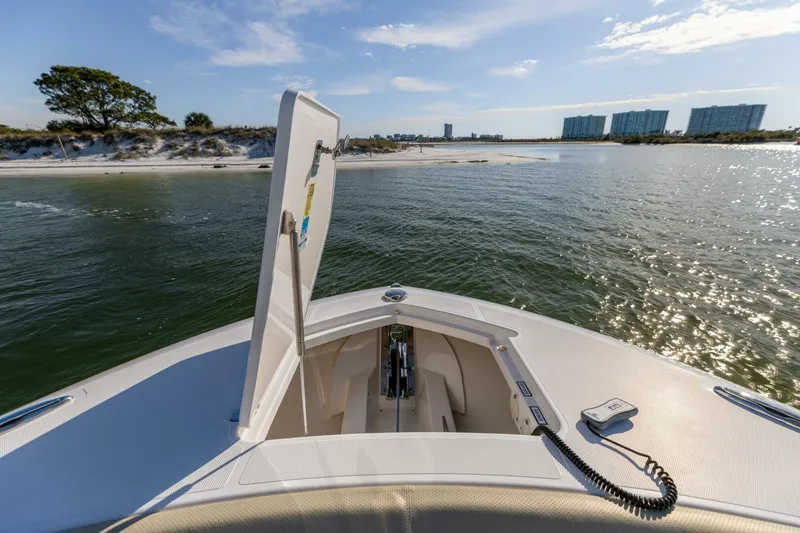 Slide: The Image of 2019 Pursuit S 368 Sport boat on water, open hatch, scenic coastal view. - 18