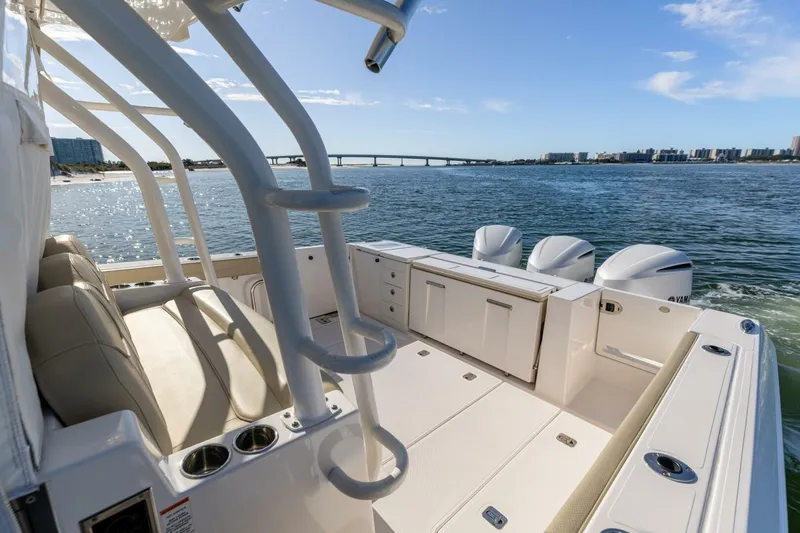 Slide: The Image of 2019 Pursuit S 368 Sport boat on water, featuring spacious deck and triple engines. - 25