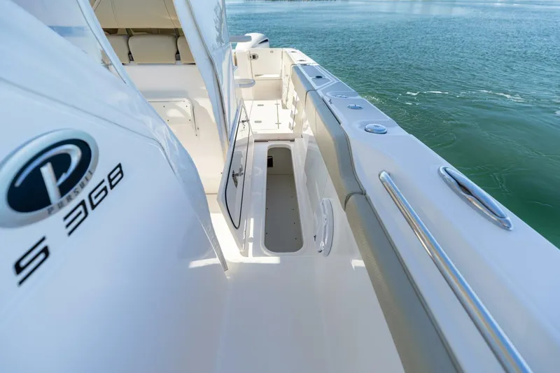 Slide: The Image of 2019 Pursuit S 368 Sport boat deck with open storage compartment, near water. - 27