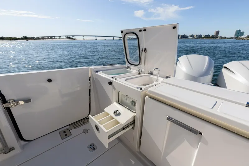 Slide: The Image of 2019 Pursuit S 368 Sport boat with open storage and sink, overlooking scenic waterway. - 29
