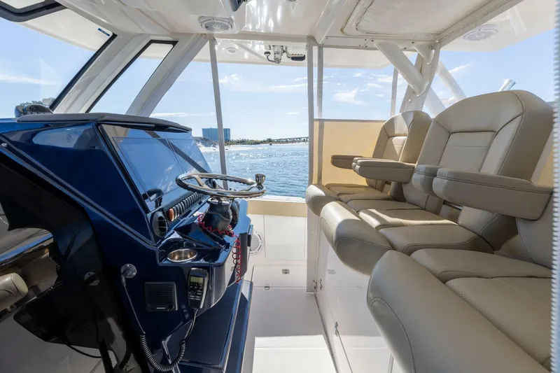 Slide: The Image of 2019 Pursuit S 368 Sport boat interior with helm and seating, overlooking ocean view. - 3