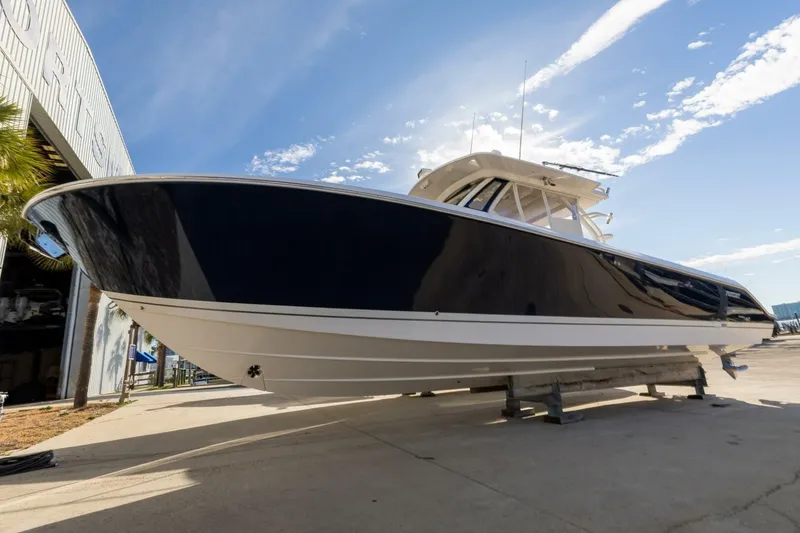Slide: The Image of 2019 Pursuit S 368 Sport boat on display outside a building under a clear sky. - 32