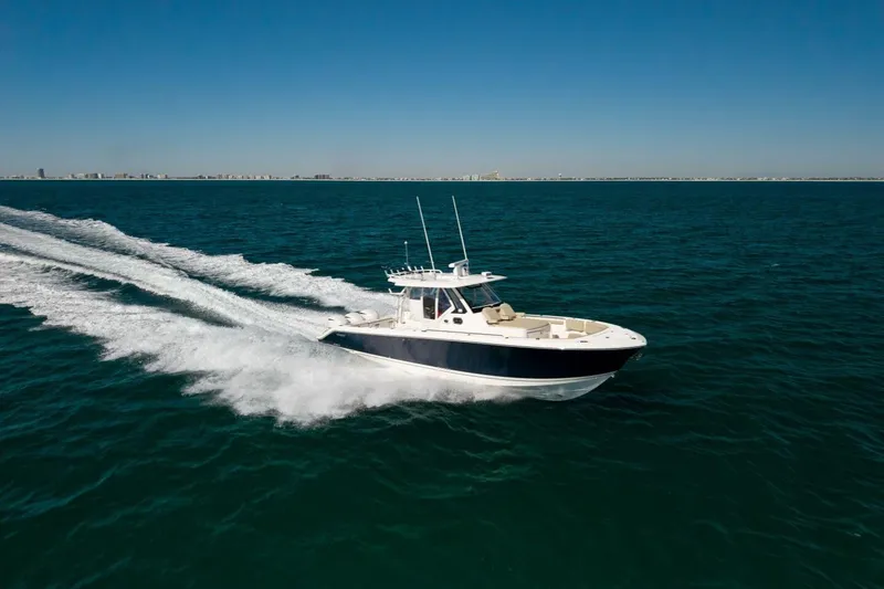 Slide: The Image of 2019 Pursuit S 368 Sport boat cruising on open water under clear blue sky. - 35