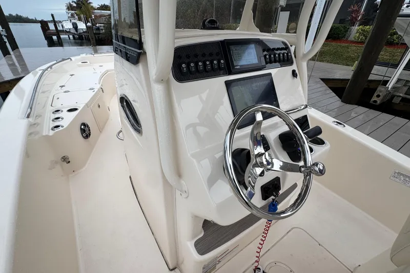Slide: The Image of 2022 Grady-White 251 Coastal Explorer boat helm with modern controls and steering wheel. - 24