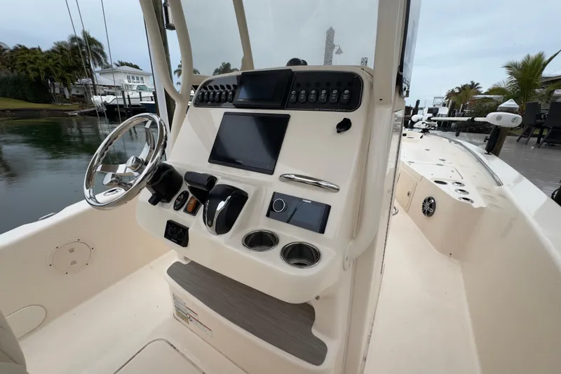 Slide: The Image of 2022 Grady-White 251 Coastal Explorer boat dashboard with steering wheel and controls. - 25