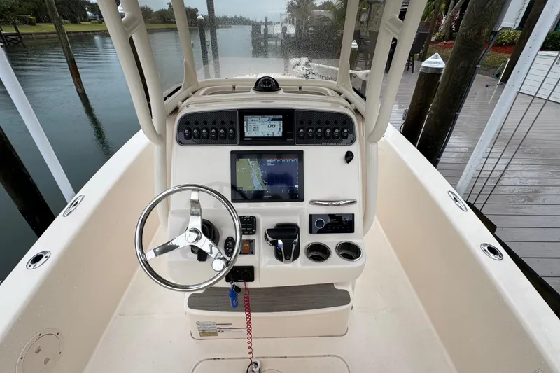 Slide: The Image of 2022 Grady-White 251 Coastal Explorer boat dashboard with steering wheel and navigation controls. - 26