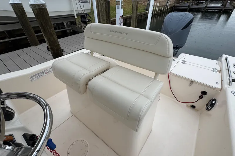 Slide: The Image of 2022 Grady-White 251 Coastal Explorer boat interior with cushioned seating and steering wheel. - 37
