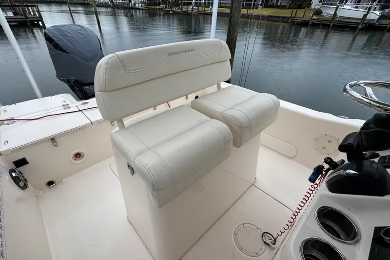 Slide: The Image of 2022 Grady-White 251 Coastal Explorer boat interior with cushioned seating and steering wheel. - 38