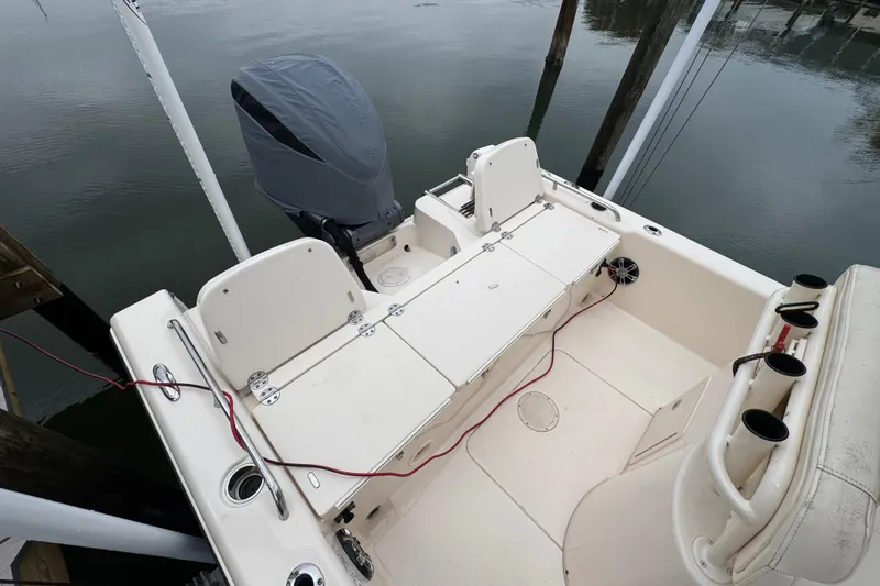 Slide: The Image of 2022 Grady-White 251 Coastal Explorer boat interior with covered engine, docked on calm water. - 40