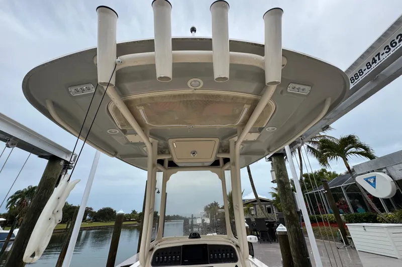Slide: The Image of 2022 Grady-White 251 Coastal Explorer boat with rod holders and canopy, docked near palm trees. - 48