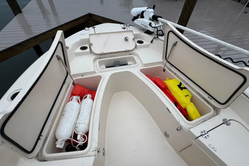 Slide: The Image of 2022 Grady-White 251 Coastal Explorer boat with open storage compartments and safety gear. - 52