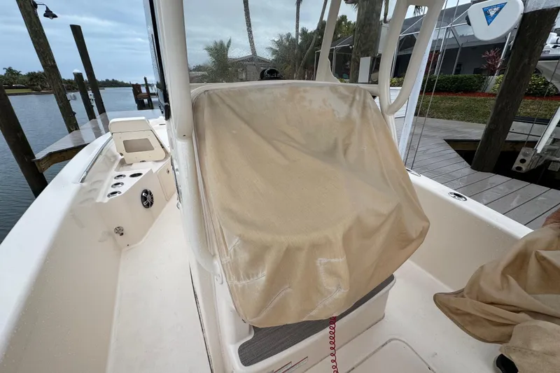 Slide: The Image of 2022 Grady-White 251 Coastal Explorer boat with covered seating, docked by the water. - 54
