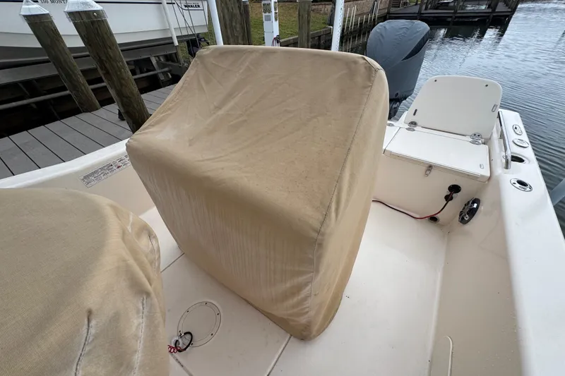 Slide: The Image of 2022 Grady-White 251 Coastal Explorer boat interior with covered seats at dock. - 56